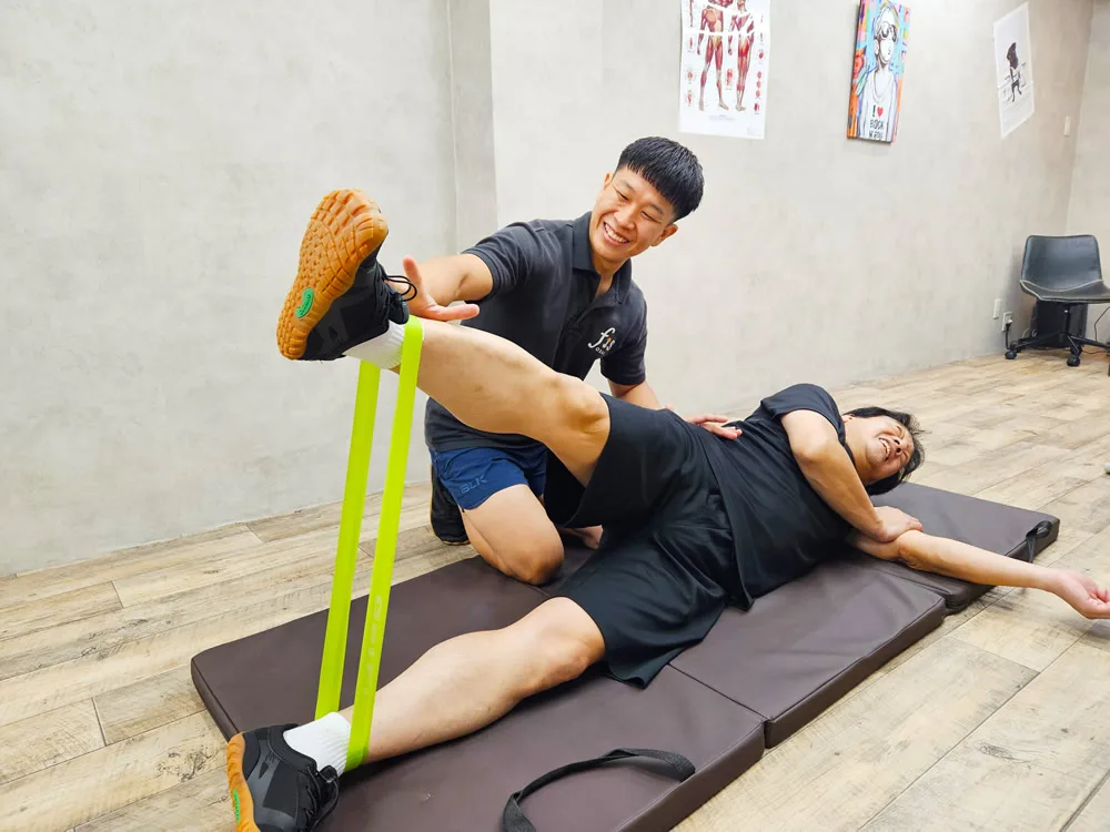 脚を持ち上げて股関節の動きを引き出しているところ